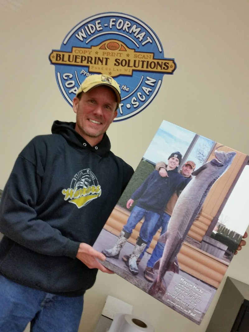 Customer holding a canvas print of a fishing photo